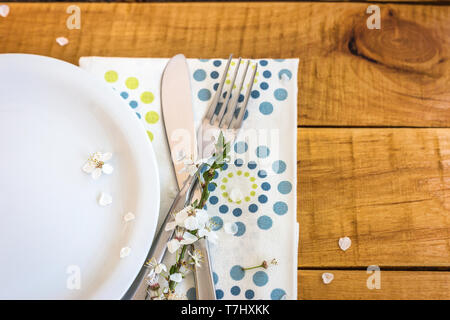 Tabelle Ambiente mit weißen Platte und die Feder Blumen auf Holztisch, Ansicht von oben mit der Kopie. Frühling Konzept. Stockfoto