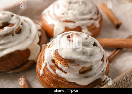 Weidenkorb mit glasierten Zimtschnecken, Nahaufnahme Stockfoto