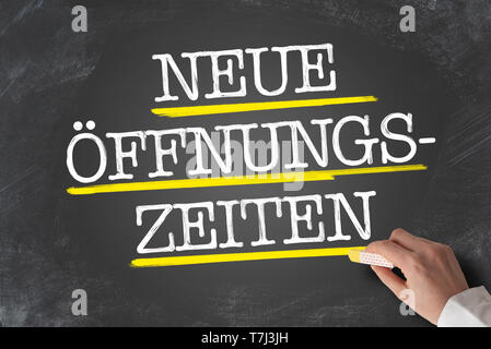 Text NEUE OFFNUNGSZEITEN, Deutsch für neue Öffnungszeiten oder geänderte Öffnungszeiten, auf die Tafel geschrieben Stockfoto