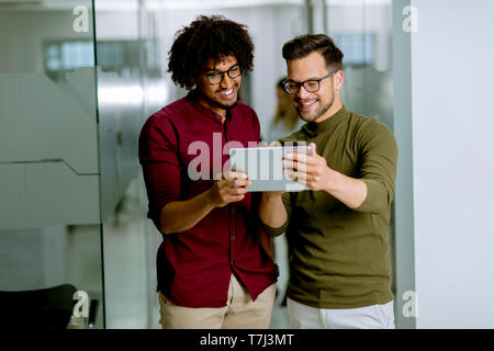 Jungen multiethnischen Geschäftspartner mit einem digitalen Tablet im Büro Stockfoto