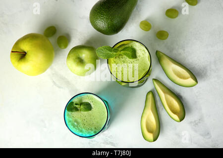 Gläser leckere avocado Smoothie und frische Früchte auf dem Tisch Stockfoto
