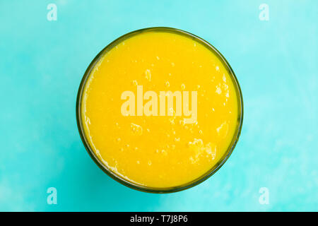 Mango Smoothie, Saft auf blauem Hintergrund. Kopieren Sie Platz. Ansicht von oben. Stockfoto