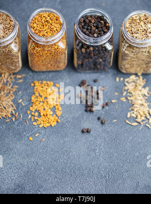 Sortimente von Gewürzen in Töpfen auf grauem Stein. Kopieren Sie Platz. Stockfoto
