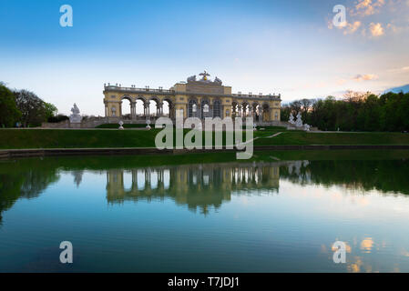 Gloriette Schönbrunn, Blick in der Abenddämmerung auf das Gloriette-Gebäude und den See auf einem Hügel über den Gärten des Schloss Schönbrunn in Wien, Österreich. Stockfoto