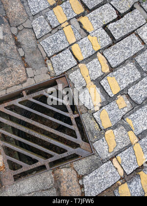 Doppelten gelben Linien auf gepflasterten Straße Oberfläche, mit ablassen. Stockfoto