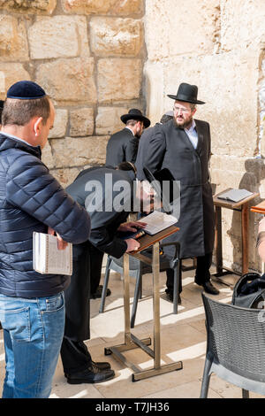 Jüdischer Mann betet neben einen Riss voller Briefe mit schriftlichen Gebet an der Klagemauer in Jerusalem. Israel Stockfoto