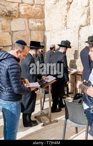 Jüdischer Mann betet neben einen Riss voller Briefe mit schriftlichen Gebet an der Klagemauer in Jerusalem. Israel Stockfoto