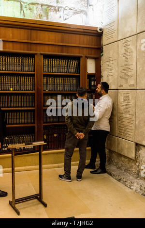 Jüdischer Mann betet neben einen Riss voller Briefe mit schriftlichen Gebet an der Klagemauer in Jerusalem. Israel Stockfoto