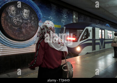 Ein Zug fährt in die U-Bahnstation Kosmonavtlar ein, die in der Sowjetzeit gebaut wurde und den Kosmonauten der Sowjetunion in der Hauptstadt Taschkent in Usbekistan gewidmet ist. Die in der ehemaligen UdSSR erbaute Taschkent Metro ist eines von nur zwei U-Bahnsystemen, die derzeit in Zentralasien betrieben werden und deren Stationen zu den kunstvoll verzierten der Welt gehören. Stockfoto