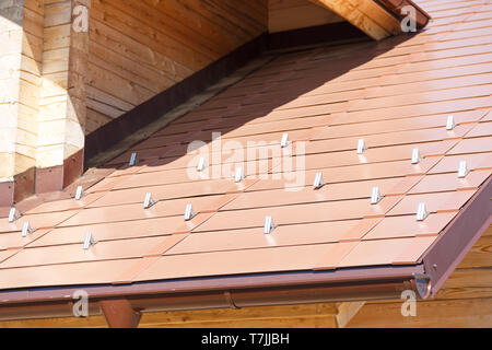 Metalldach mit schneefanggitter Stockfoto