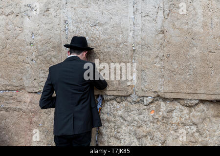 Jerusalem, Israel, 27-März-2019: jüdische Mensch betet Neben einem Riss mit Briefe mit schriftlichen Gebet an der Klagemauer in Jerusalem gefüllt. Isra Stockfoto