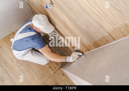 Abdichtung fertigen Keramische Fliesen Badezimmer Duschkabine. Kaukasische Bauarbeiter in seinen 30ern. Industrielle Thema. Stockfoto