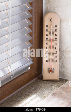 Eine Holz- thermometer mit einem analogen Skala Messung der Temperatur in der Nähe der Fenster Stockfoto