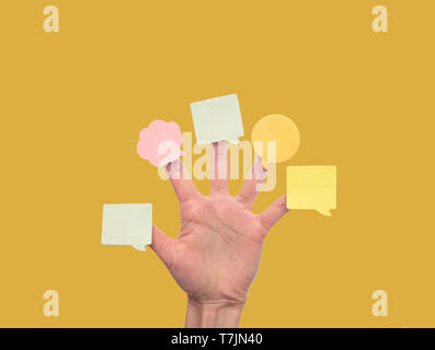 Farbige Aufkleber an den Fingern auf gelbem Hintergrund geklebt. Stockfoto