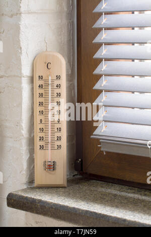 Eine Holz- thermometer mit einem analogen Skala Messung der Temperatur in der Nähe der Fenster Stockfoto