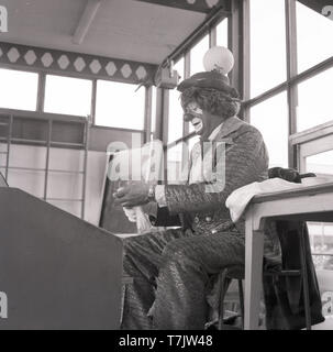 1960, historische, einem Zirkus Clown in einer Schule Hall, London, England, UK. Stockfoto