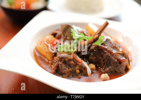 Rindfleisch Massaman Curry mit Reis und Salat auf Holz- Hintergrund, Thai Food Stockfoto