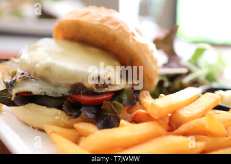 Rindfleisch Hamburger mit Pommes Frites und Salat auf hölzernen Hintergrund Stockfoto