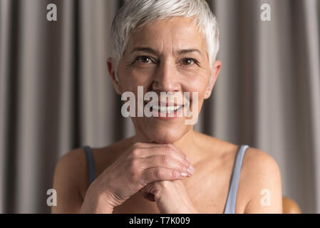 Natürliche schöne ältere Frau mit kurzen grauen Haaren an Kamera suchen, natürliche Schönheit Konzept Stockfoto