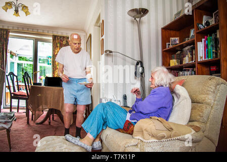 93 Jahre alter Mann mit Herz Zustand sorgt durch seine stark Sehbehinderte 90 Jahre alte Frau und Köche, prepaeres Mahlzeiten und die Hausarbeit für Sie. Stockfoto