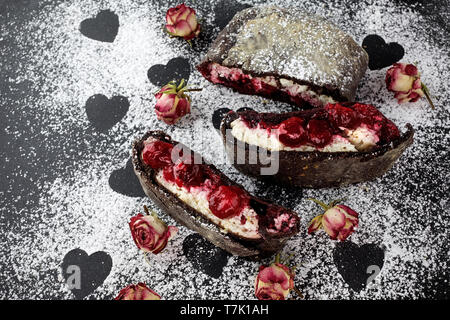 Apfelstrudel mit einer Kirsche. Cherry pie. Kuchen, Apfelstrudel mit Beeren auf schwarzem Hintergrund Stockfoto