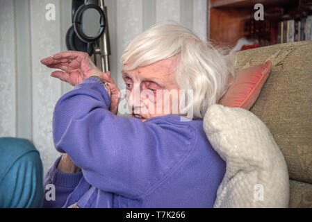 Ein blinder 90 Jahre alte Dame, mit schweren Makuladegeneration de-Generation kann nur die Zeit es sagen hören mit ihr zu sprechen. Stockfoto