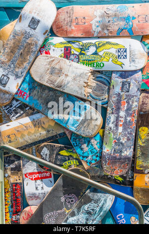 Ein Haufen von Preowned skateboard Decks in einem zufällig angeordnet sind einige kaputte und einige Ganze mit jeweils einem unterschiedlichen Design Pattern vor einem Stockfoto