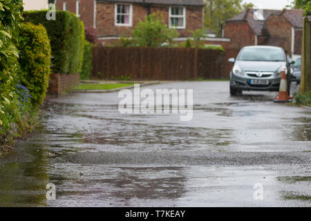 Ashford, Kent, Großbritannien. 8. Mai, 2019. UK Wetter: Die Aussichten für den Tag ist heavy rain mit maximalen Temperaturen von 12 °C, helleres Wetter wird später an diesem Abend erwartet. Ein Postmitarbeiter geht über sein Geschäft die Briefzustellung trotz der schrecklichen Bedingungen. © Paul Lawrenson 2019, Foto: Paul Lawrenson/Alamy leben Nachrichten Stockfoto