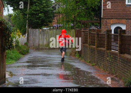 Ashford, Kent, Großbritannien. 8. Mai, 2019. UK Wetter: Die Aussichten für den Tag ist heavy rain mit maximalen Temperaturen von 12 °C, helleres Wetter wird später an diesem Abend erwartet. Ein Postmitarbeiter geht über sein Geschäft die Briefzustellung trotz der schrecklichen Bedingungen. © Paul Lawrenson 2019, Foto: Paul Lawrenson/Alamy leben Nachrichten Stockfoto