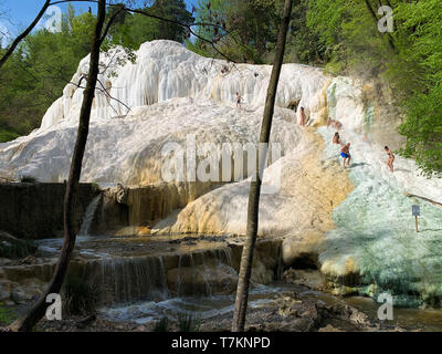 Bagni San Filippo, Italien - 24 April 2019: Menschen Ruhe auf den thermischen Salz Wasserfälle der Mineralquellen von Bagni San Filippo an einem sonnigen Tag. Stockfoto