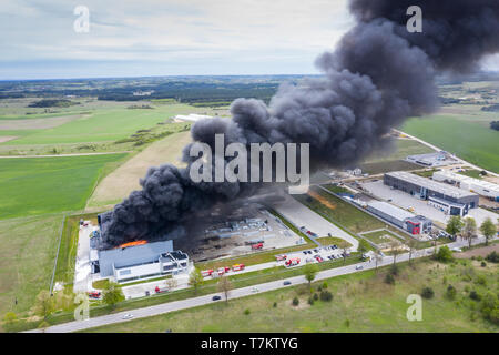 Top down Sicht der Rauchwolken von verbrannten Lagergebäude mit verbrannten Dach, Feuer Katastrophe Unfall in Cargo Logistics storehouse Stockfoto