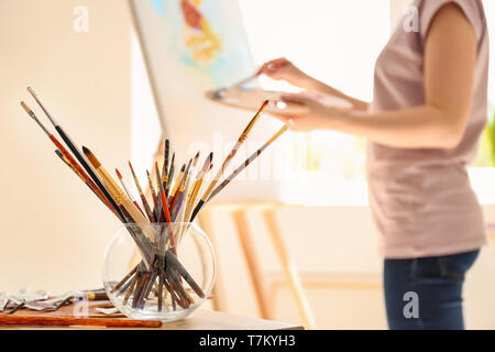 Satz von Pinsel und andere Werkzeuge auf Tabelle in Artist's workshop Stockfoto