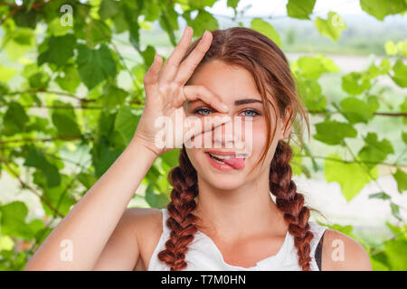 Freundlich lächelnde Mädchen zeigt Geste alles OK in der Natur Stockfoto