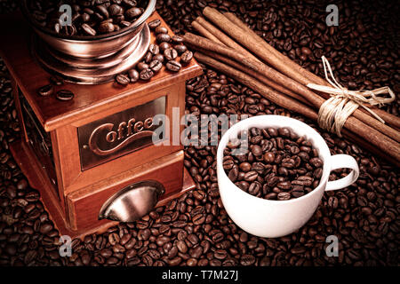 Kaffee Mühle mit einer Tasse Kaffee und Zimt Stockfoto