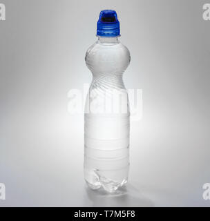 Transparenter Kunststoff Flasche mit einem blauen Kork mit einem Trinker mit Wasser gefüllt. Stockfoto