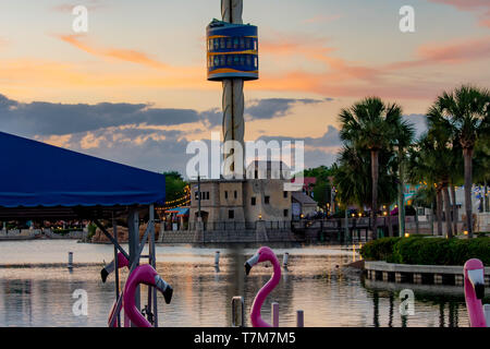 Orlando, Florida. April 7, 2019. Teilansicht der Swan Tretboote, Sky Tower und Palmen auf bunten Sonnenuntergang backgroun in Seaworld in Internationa Stockfoto