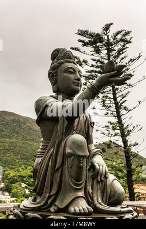 Hong Kong, China - 7. März 2019: Insel Lantau. Closeup, einer der sechs Devas bietet Blume zu Tian Tan Buddha. Bronzestatue von vorne gesehen mit gr Stockfoto