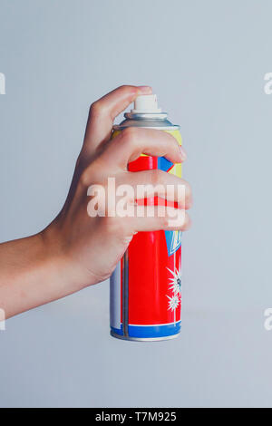 Person mit einem Spray für das Töten von Mücken, Aerosol gegen Mücken und Fliegen. Mückenbekämpfung oder Killer spray im Einsatz gegen den weißen Hintergrund. Stockfoto