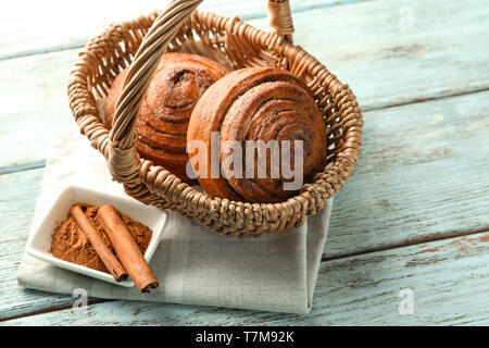 Weidenkorb mit Zimt, die Brötchen auf dem Tisch Stockfoto