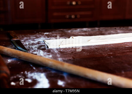 Vorbereiten der hausgemachte Pasta in der Küche. Lange Teig stripe für Kochen Pasta. Hausgemachte Speisen Vorbereitung Konzept. Stockfoto