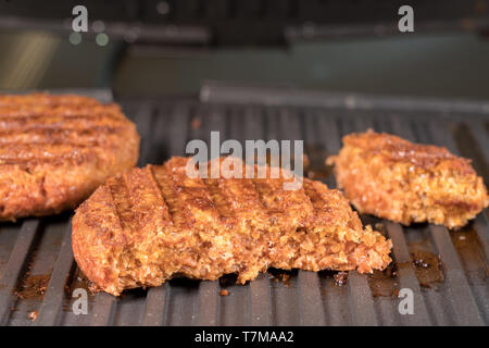 Nahaufnahme von pflanzlichen burger Pastetchen auf Grillpfanne gegrillt werden Stockfoto