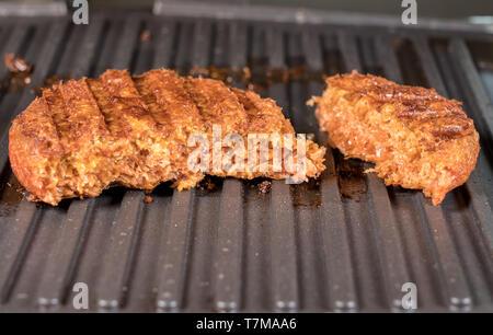Nahaufnahme von pflanzlichen burger Pastetchen auf Grillpfanne gegrillt werden Stockfoto