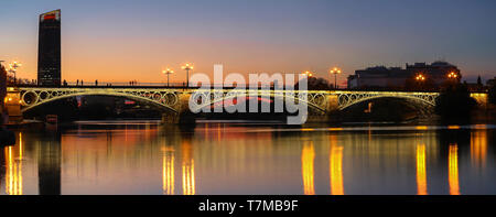 Triana Brücke über den Fluss Guadalquivir bei Sonnenuntergang, Sevilla, Andalusien, Spanien Stockfoto