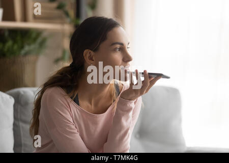 Frau mit Smartphone mithilfe virtueller Assistent oder sprechen Sie über die Freisprechanlage Stockfoto