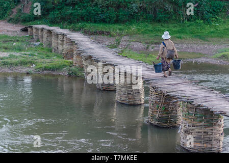 Eine Frau über eine Brücke in Luang Namtha, Laos Stockfoto