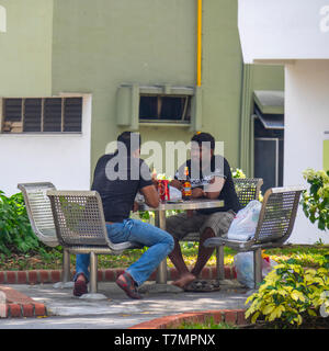 Zwei Männer in einem Garten sitzen und Bier trinken. Stockfoto