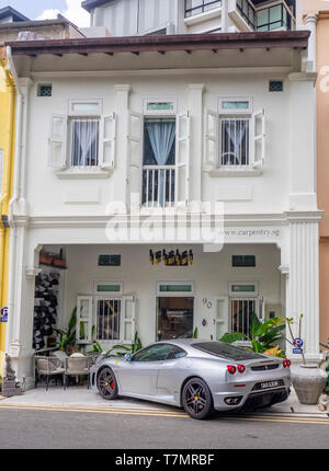 Silber Ferrari vor einem Geschäftshaus in Singapur geparkt. Stockfoto