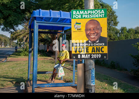 Johannesburg, Südafrika, 7. Mai, 2019. Ein Mann wartet an einer Bushaltestelle als ANC Wahlplakat ist in emmarentia am Vorabend der Wahlen auf nationaler Ebene gesehen, Mai 8. Credit: Eva-Lotta Jansson/Alamy Stockfoto