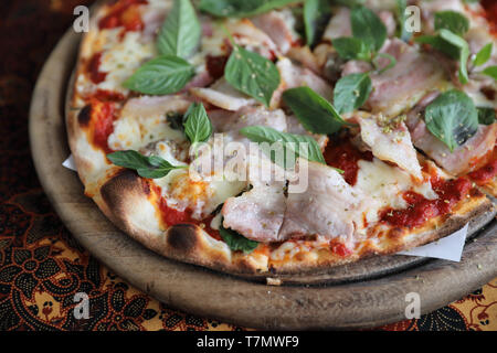 Pizza mit Schinken, Speck und Gemüse, italienisches Essen Stockfoto