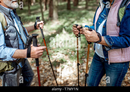 Älterer Mann und Frau wandern mit Trekking Stöcke im Wald, in der Nahaufnahme mit 7/8-Gesicht Stockfoto